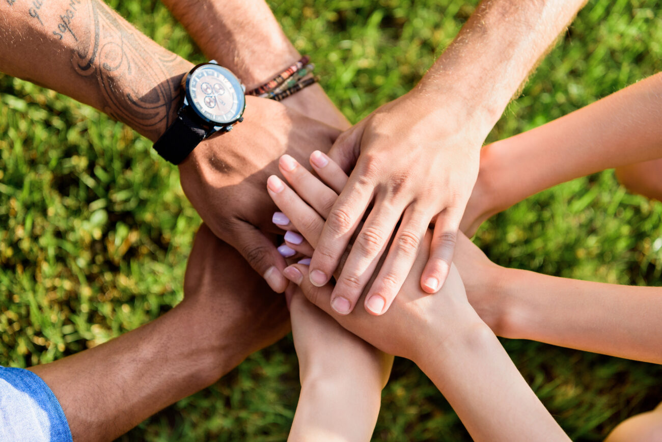 Cropped shot of multiracial friends overlapping hands together
