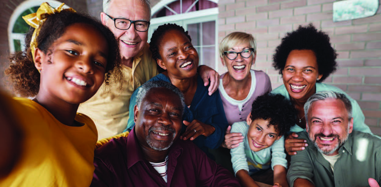 Diverse age and race group of people smiling for the camera.